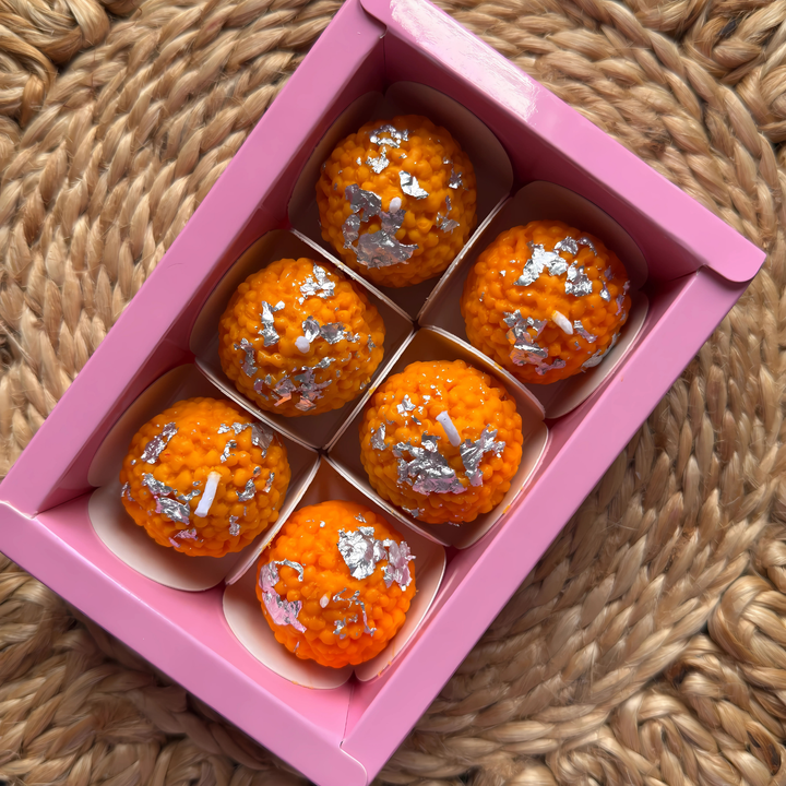 “Set of 6 laddu-shaped soy wax candles in festive packaging”