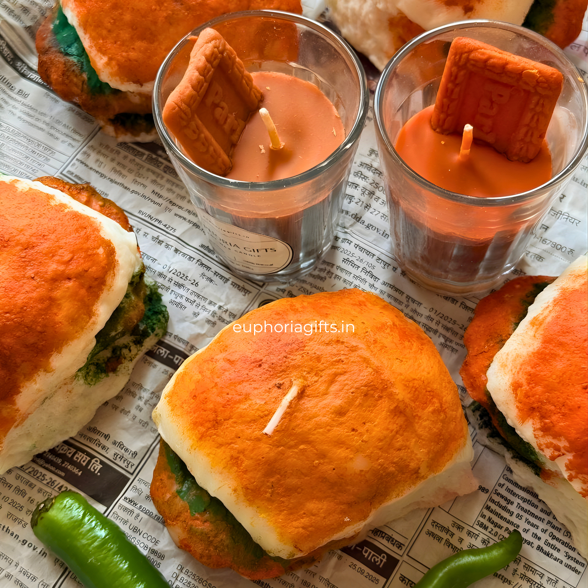 Candle-shaped sandwiches with orange buns and green fillings, placed on a newspaper background.