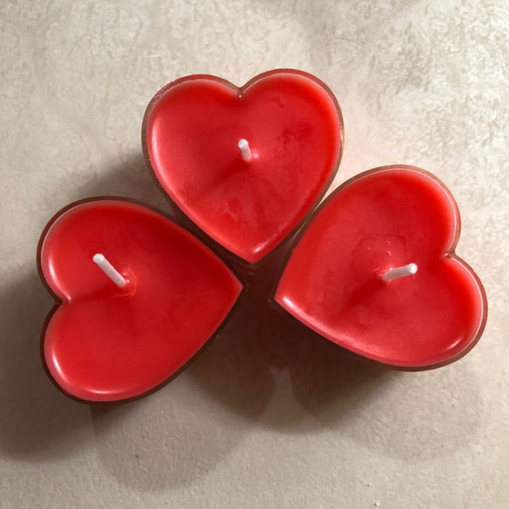 Pink heart-shaped candle with a flame on a white background, featuring the brand 'euphoriagifts.in'.