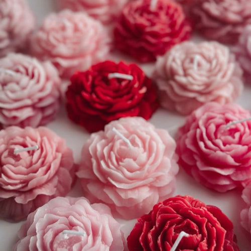 Pink and red peony-shaped candles with layered rose-like petals, arranged aesthetically. aesthetic candles

gift candles

wedding décor candles

romantic candle gift

flower-shaped candles