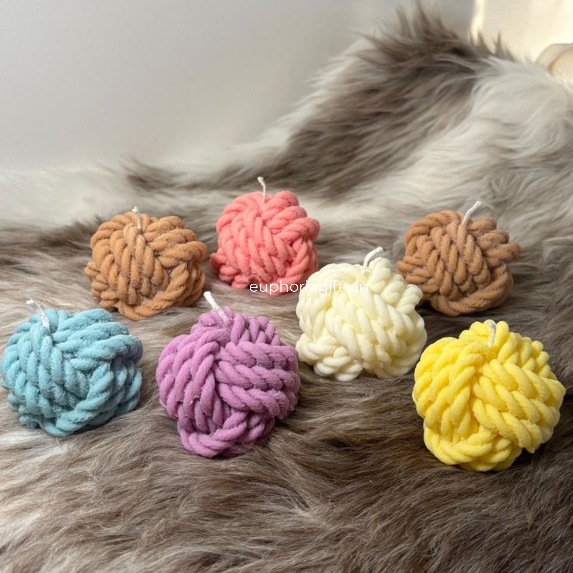 Vibrant handmade soy wax yarn candles in assorted colors – cozy home décor accents by Euphoria Gifts (Seven colorful candles on fur