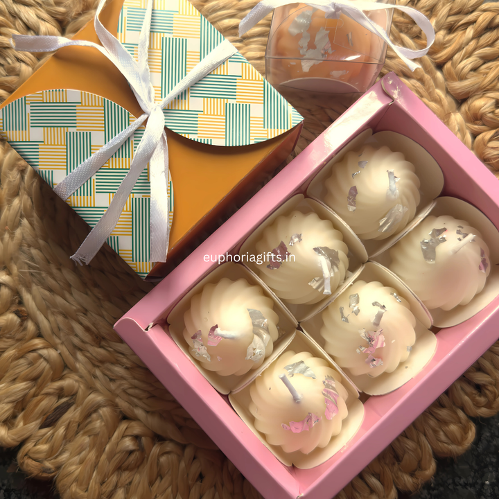 Handmade modak candles for Diwali gifting and Ganpati decoration Pink box of modak candle with decorative packaging on a textured surface