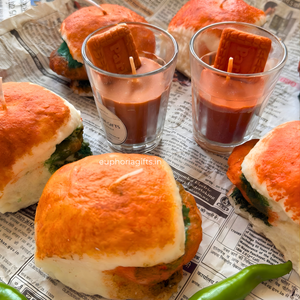 Bread rolls with green filling and small glasses of red sauce on a newspaper background.