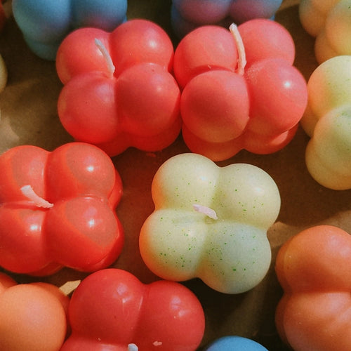 Bright and cheerful mini bubble candles in mixed colors under sunlight – cute soy wax candles for gifting or decoration.