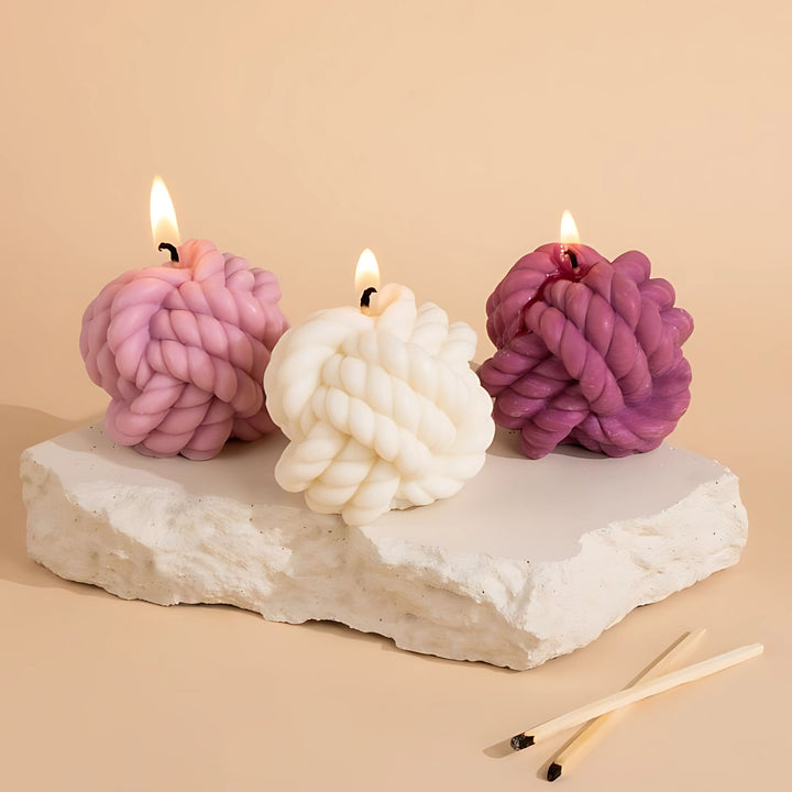 Three lit candles on a rock slab)

Aesthetic lit woolen knot candles – hand-poured soy wax candles in pink, white, and purple by Euphoria Gifts